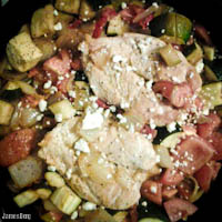 Roast chicken breast with tomatoes, zucchini, onions, and sundried tomatoes in a light red wine and oregano sauce with feta cheese